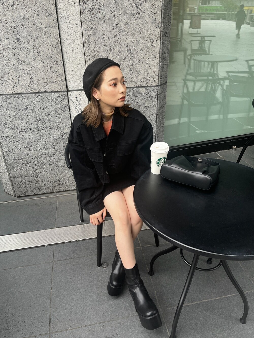 オレンジ系のTシャツ/カットソー、ブラック系のデニムジャケット、ブラック系のスカートを着用したレディースの夏コーディネートの3枚目の写真