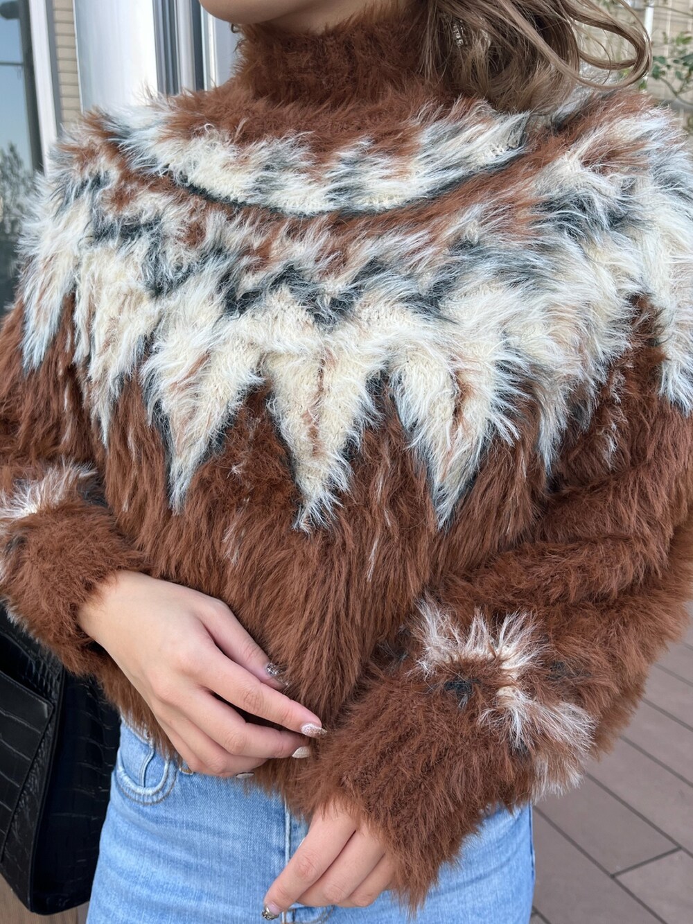 ブラウン系のニット/セーター、ブラック系のブーツを着用したレディースの冬コーディネートの6枚目の写真