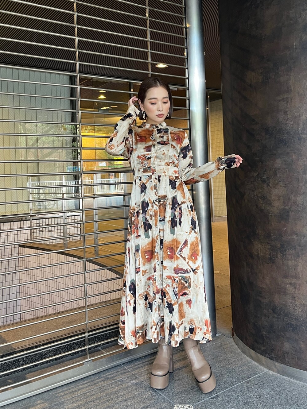 ブラウン系のブーツ、オレンジ系のワンピースを着用したレディースの秋コーディネートの2枚目の写真