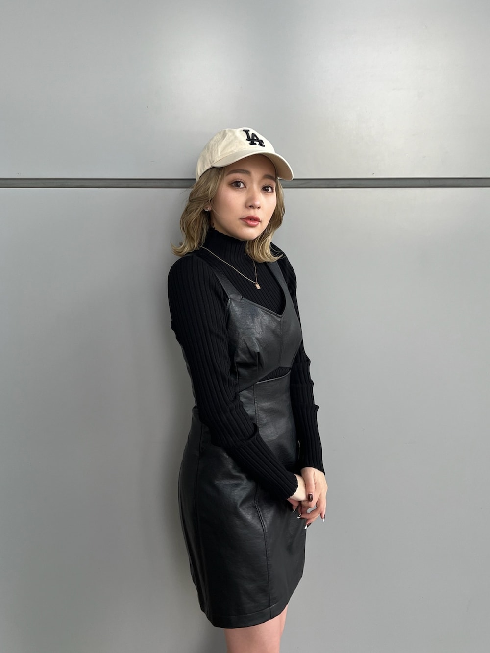 ブラック系のワンピース、ブラック系のニット/セーター、グレー系のスニーカーを着用したレディースの冬コーディネートの5枚目の写真