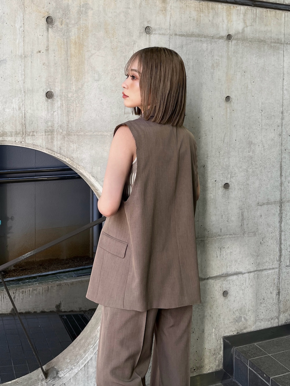 ブラウン系のベスト、ホワイト系のタンクトップ、ブラウン系のその他パンツを着用したレディースの夏コーディネートの5枚目の写真