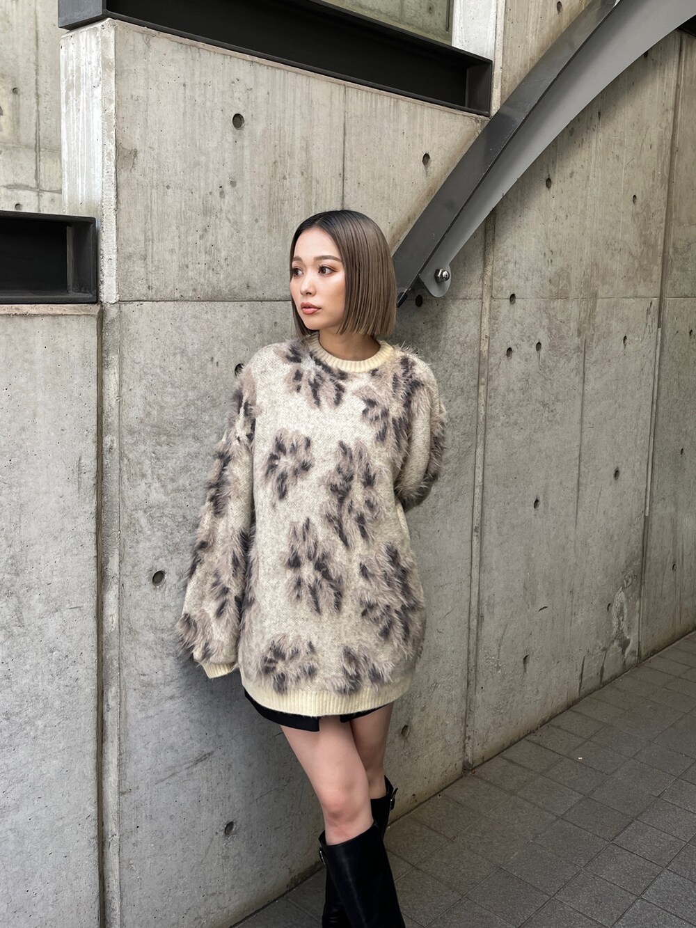 ホワイト系のニット/セーター、ブラック系のブーツを着用したレディースの秋コーディネートの5枚目の写真