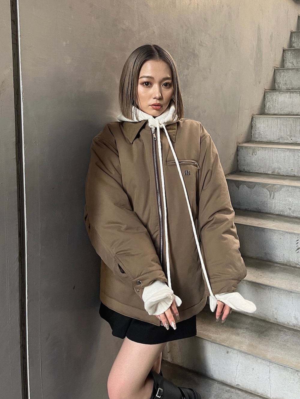 ブラウン系のブルゾン、ブラック系のブーツを着用したレディースの秋コーディネートの7枚目の写真