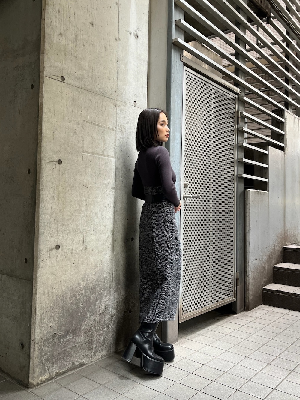 グレー系のニット/セーター、ブラック系のブーツを着用したレディースの夏コーディネートの2枚目の写真