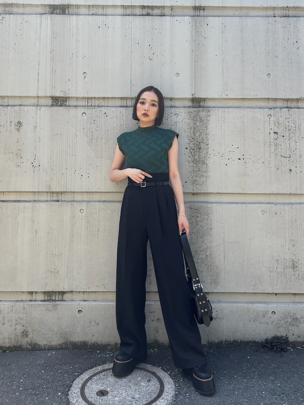 グリーン系のニット/セーター、ブラック系のその他パンツ、ブラック系のブーツを着用したレディースの夏コーディネートの3枚目の写真