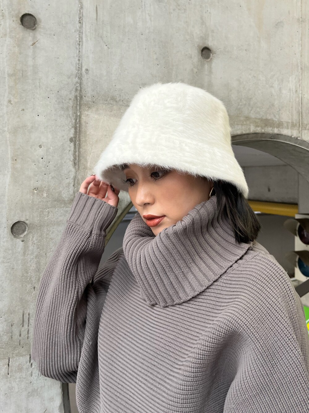 ブラウン系のニット/セーター、ブルー系のスカート、ブラック系のブーツを着用したレディースの夏コーディネートの4枚目の写真