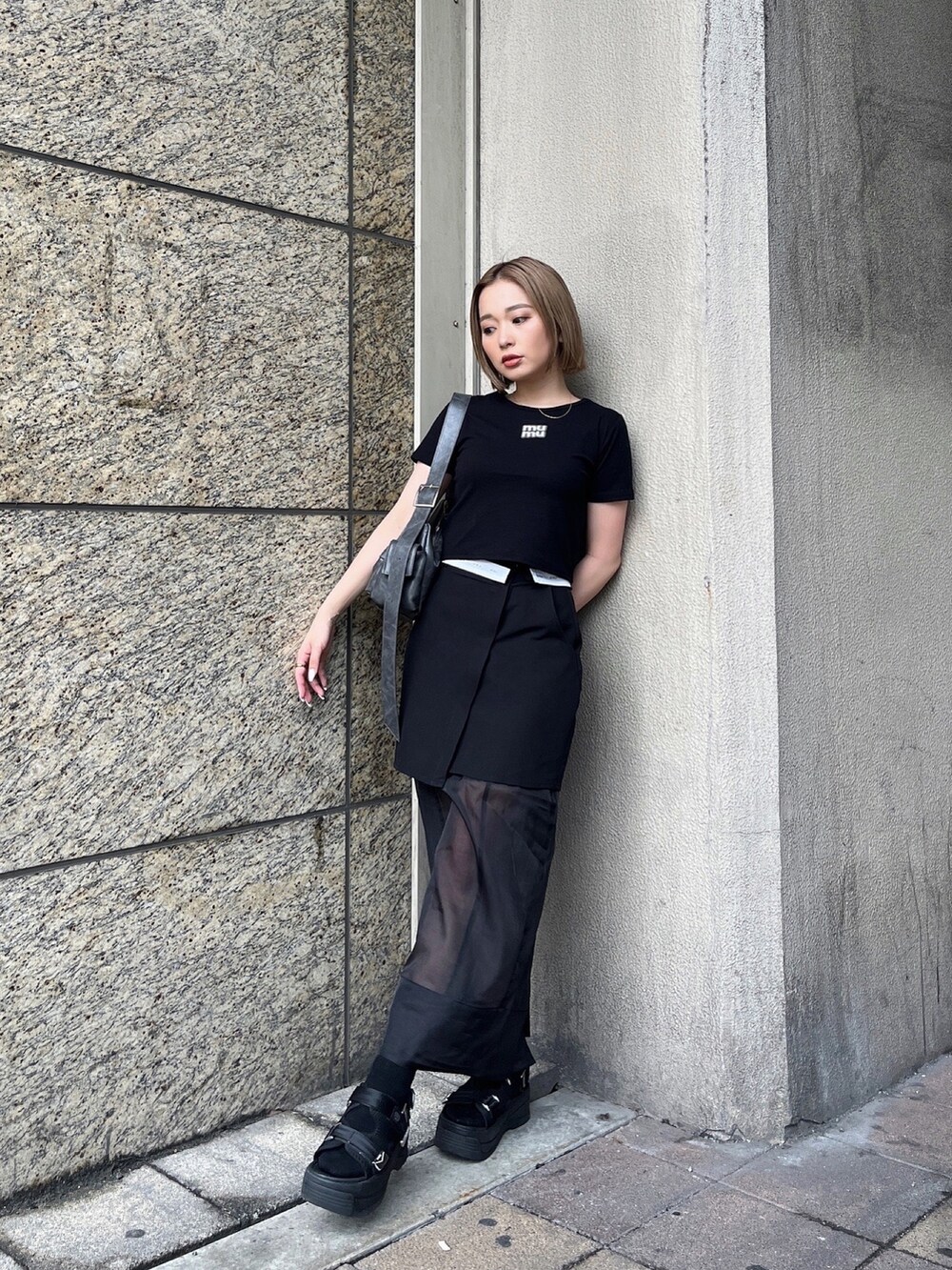 ブラック系のTシャツ/カットソー、ブラック系のスカート、ブラック系のサンダルを着用したレディースの夏コーディネートの2枚目の写真