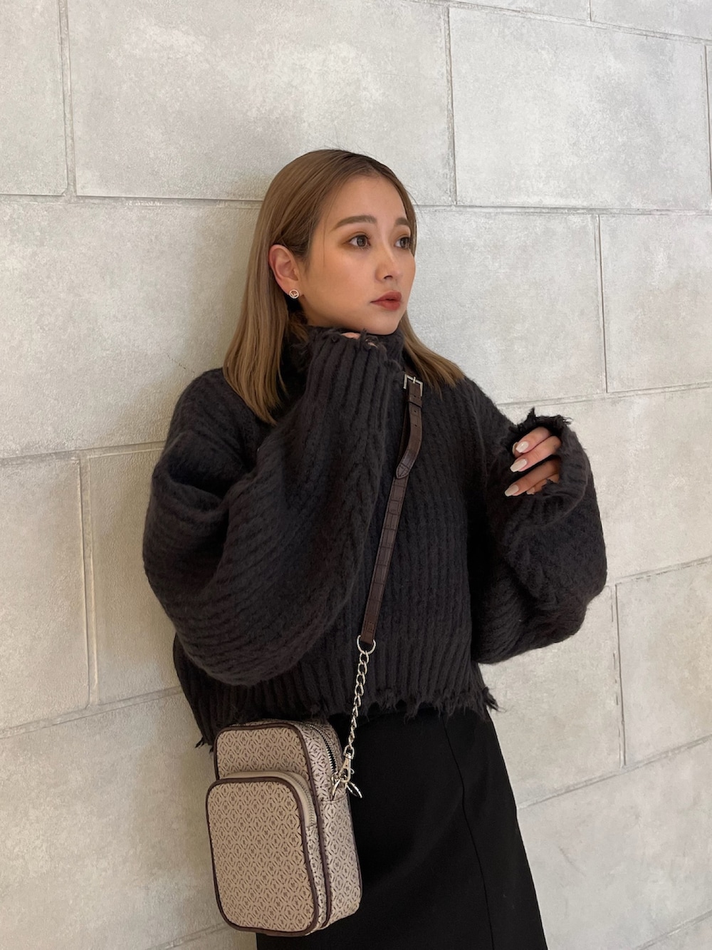 グレー系のニット/セーター、その他のショルダーバッグ、ブラック系のスカートを着用したレディースの秋コーディネートの6枚目の写真
