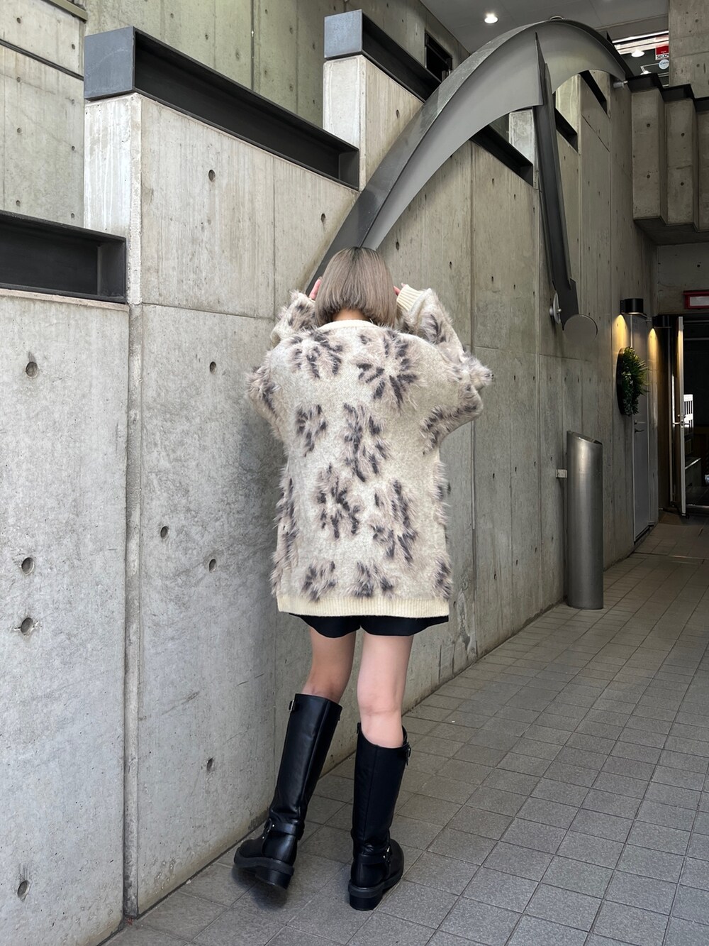 ホワイト系のニット/セーター、ブラック系のブーツを着用したレディースの秋コーディネートの3枚目の写真