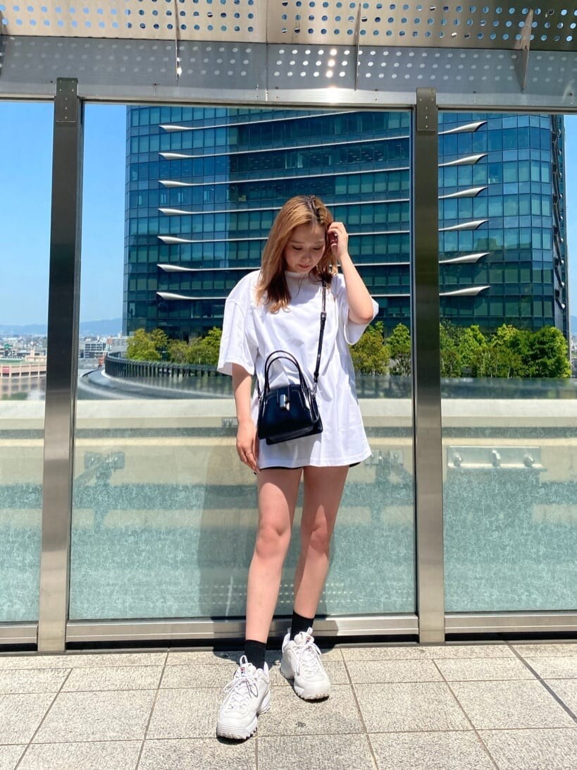 ブラック系のその他パンツ、ブラック系のハンドバッグ、ホワイト系のTシャツ/カットソーを着用したレディースの春コーディネートの2枚目の写真