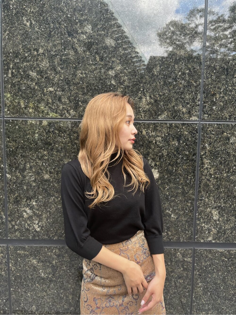 ブラック系のブーツ、ブラック系のニット/セーター、ブラウン系のスカートを着用したレディースの秋コーディネートの5枚目の写真