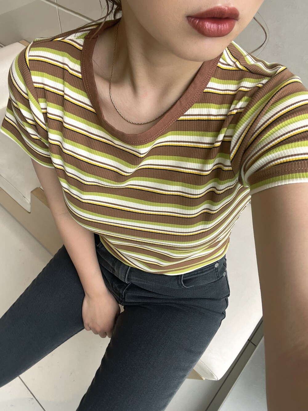 イエロー系のTシャツ/カットソー、グレー系のデニムパンツ、ブラック系のサンダルを着用したレディースの春コーディネートの3枚目の写真