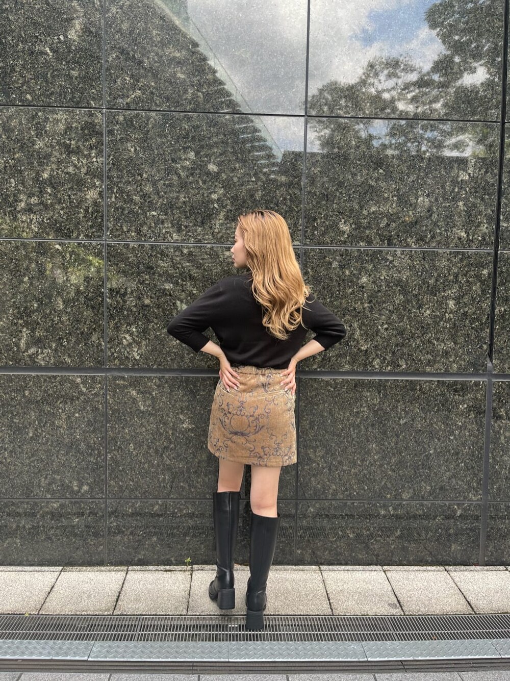 ブラック系のブーツ、ブラック系のニット/セーター、ブラウン系のスカートを着用したレディースの秋コーディネートの4枚目の写真