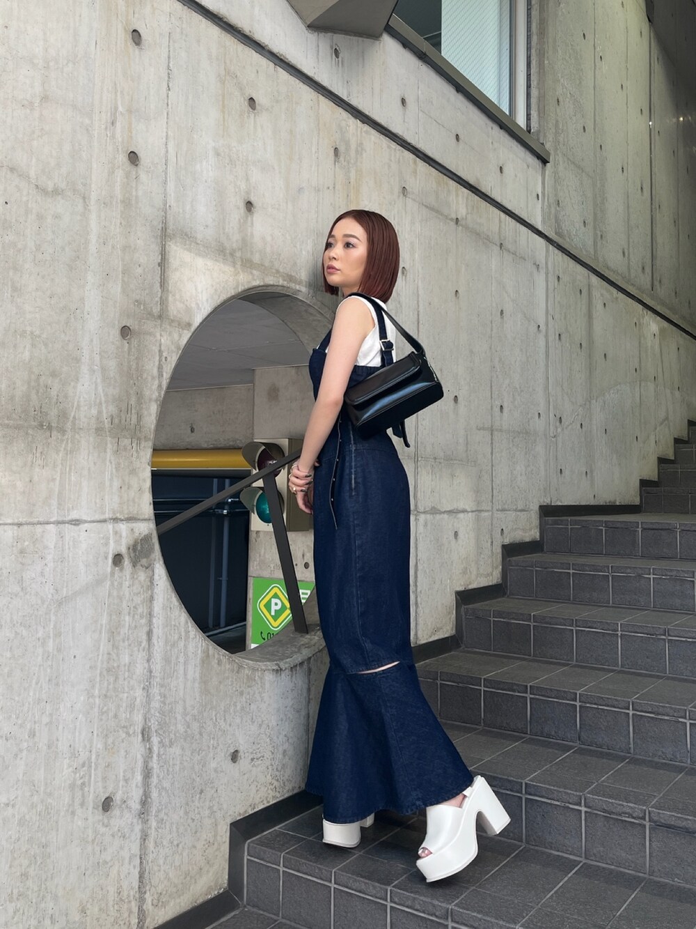 ホワイト系のタンクトップ、ホワイト系のサンダル、ブラック系のショルダーバッグを着用したレディースの春コーディネートの2枚目の写真