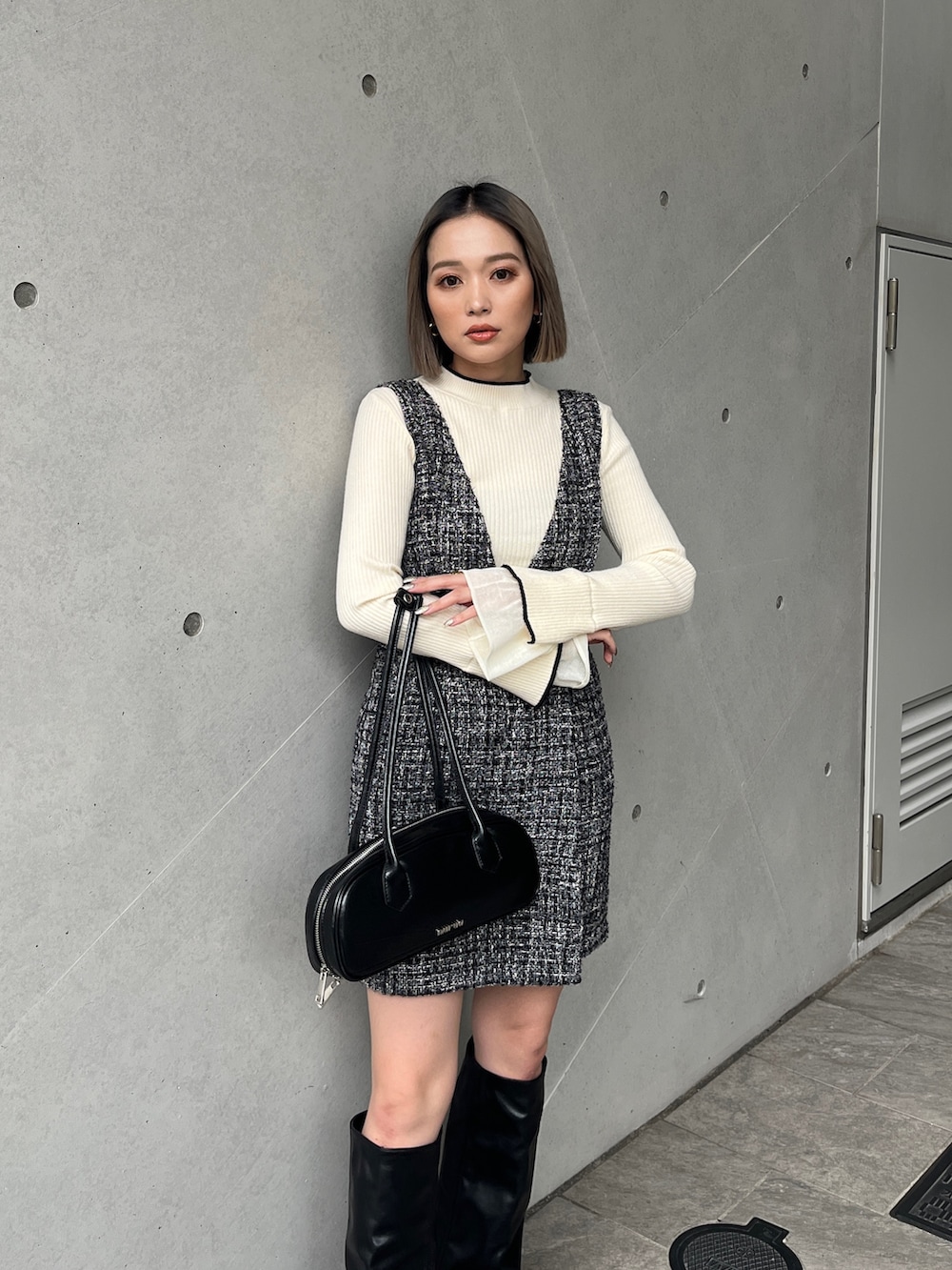 ホワイト系のニット/セーター、グレー系のワンピース、ブラック系のブーツを着用したレディースの秋コーディネートの3枚目の写真