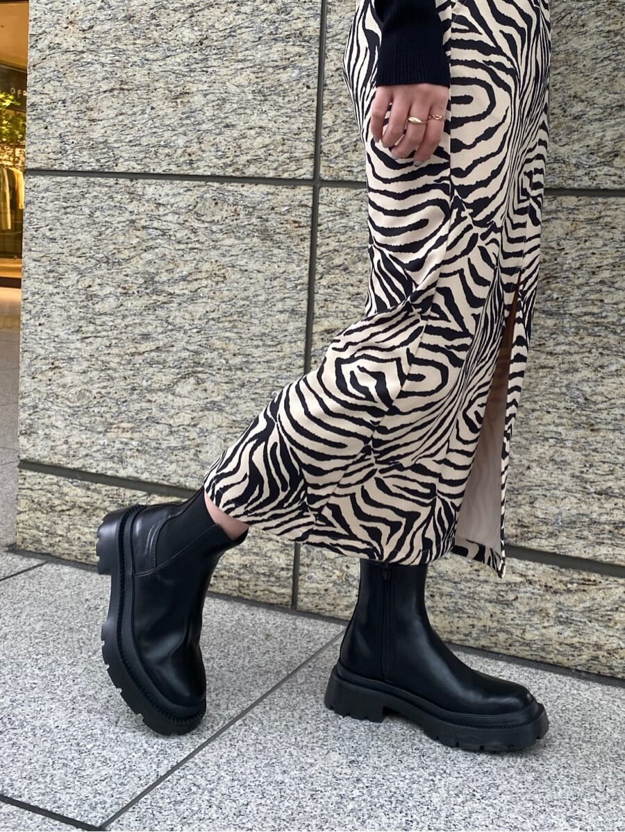 ブラック系のブーツ、その他のスカート、ブラック系のニット/セーターを着用したレディースの春コーディネートの6枚目の写真