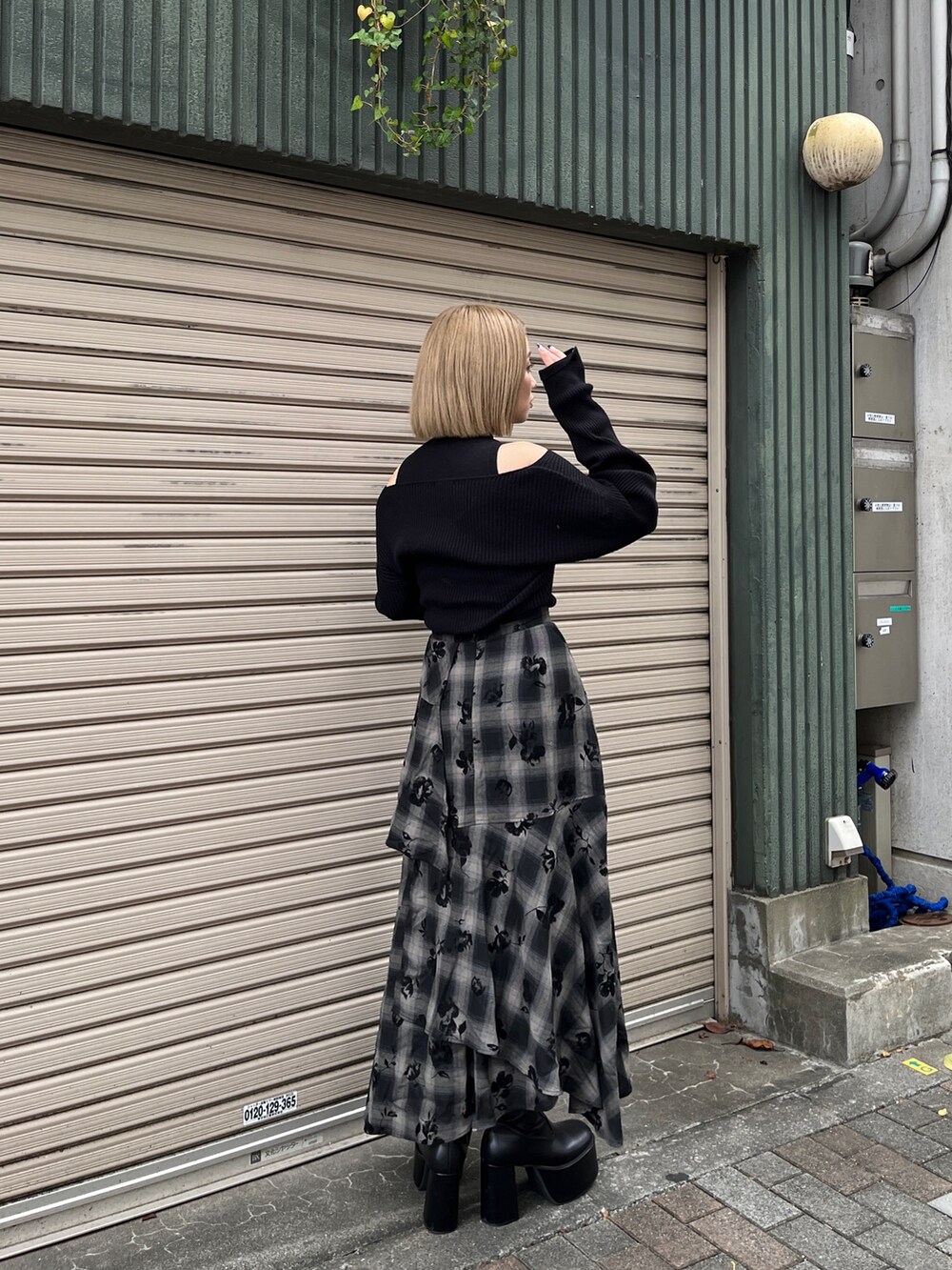 ブラック系のニット/セーター、ブラック系のスカート、ホワイト系のトートバッグを着用したレディースの冬コーディネートの4枚目の写真