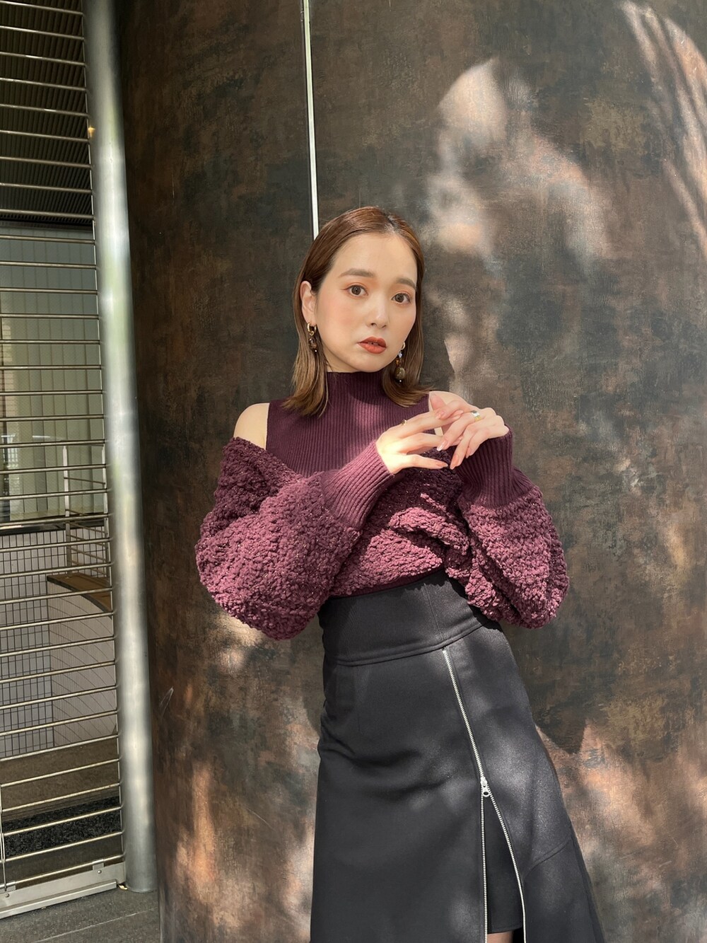 ブラック系のスカート、レッド系のニット/セーター、ブラウン系のブーツを着用したレディースの秋コーディネートの2枚目の写真