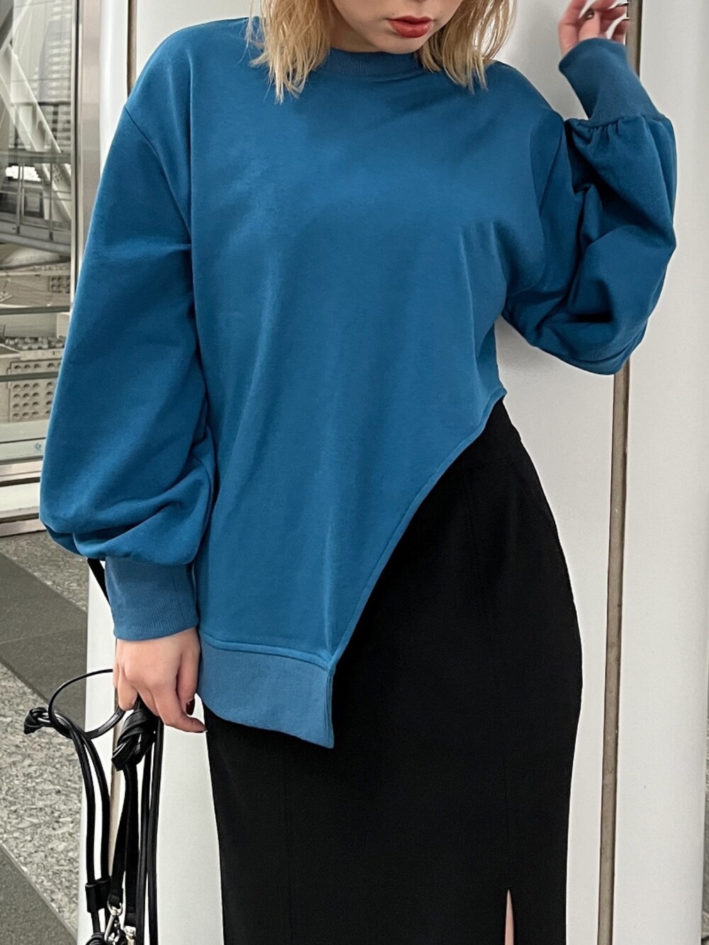 ブルー系のTシャツ/カットソー、ブラック系のスカート、ブラック系のハンドバッグを着用したレディースの冬コーディネートの8枚目の写真