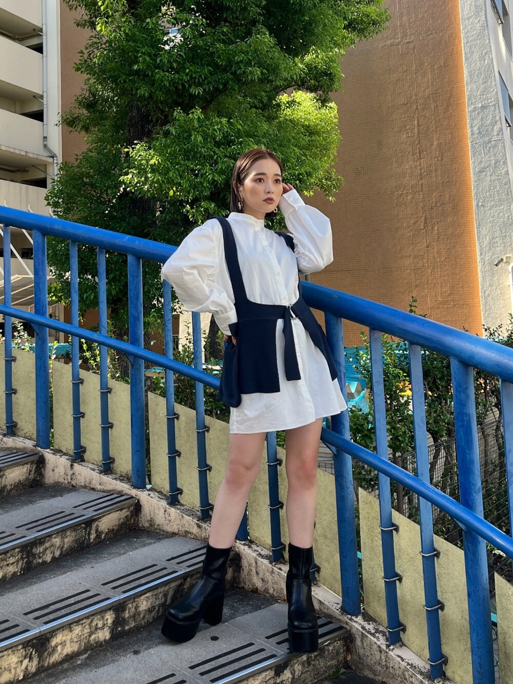 ホワイト系のワンピース、ブラック系のブーツを着用したレディースの夏コーディネートの3枚目の写真