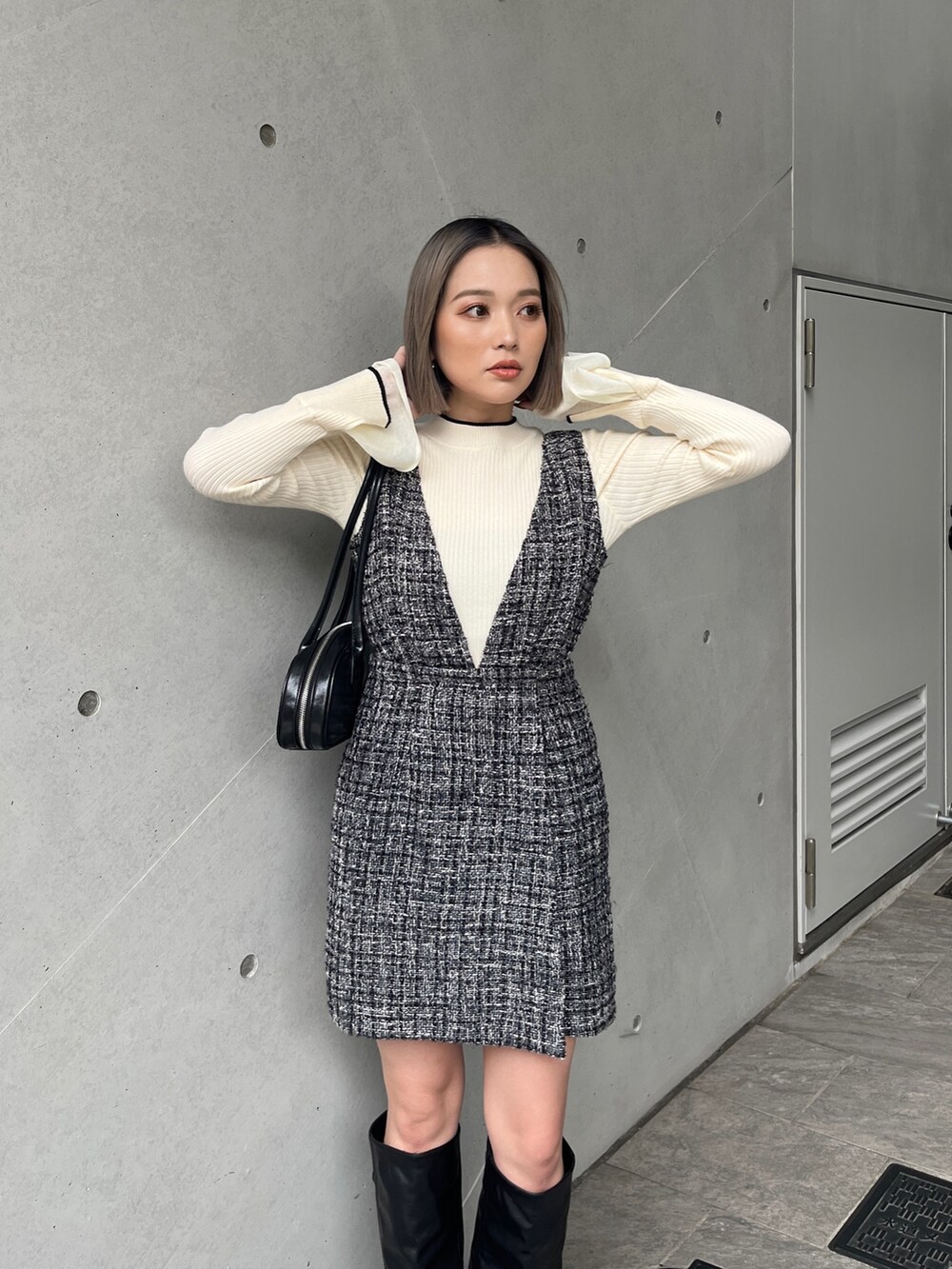 ホワイト系のニット/セーター、グレー系のワンピース、ブラック系のブーツを着用したレディースの秋コーディネートの4枚目の写真