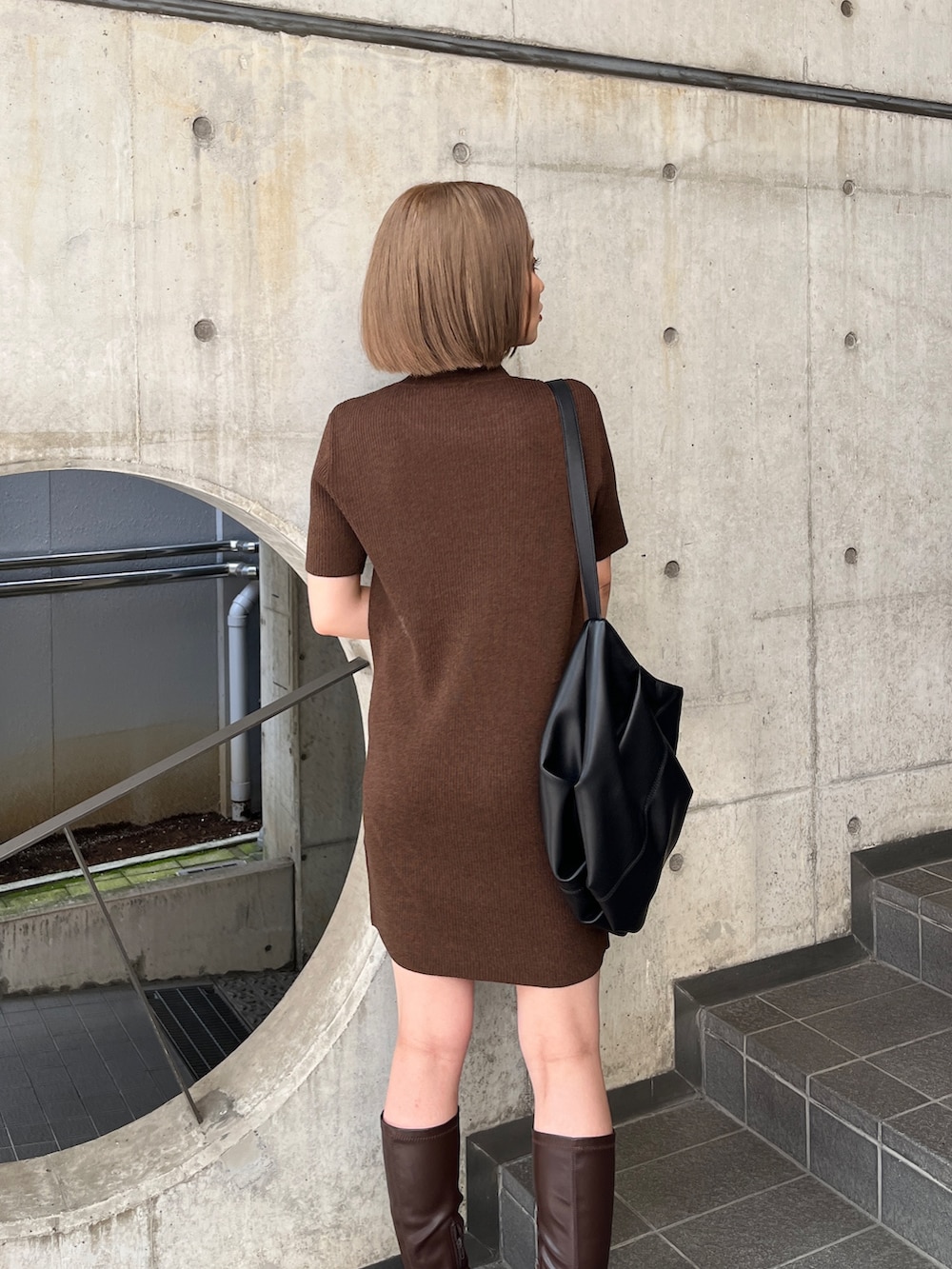 ブラウン系のワンピース、ブラウン系のブーツ、ブラック系のハンドバッグを着用したレディースの夏コーディネートの6枚目の写真