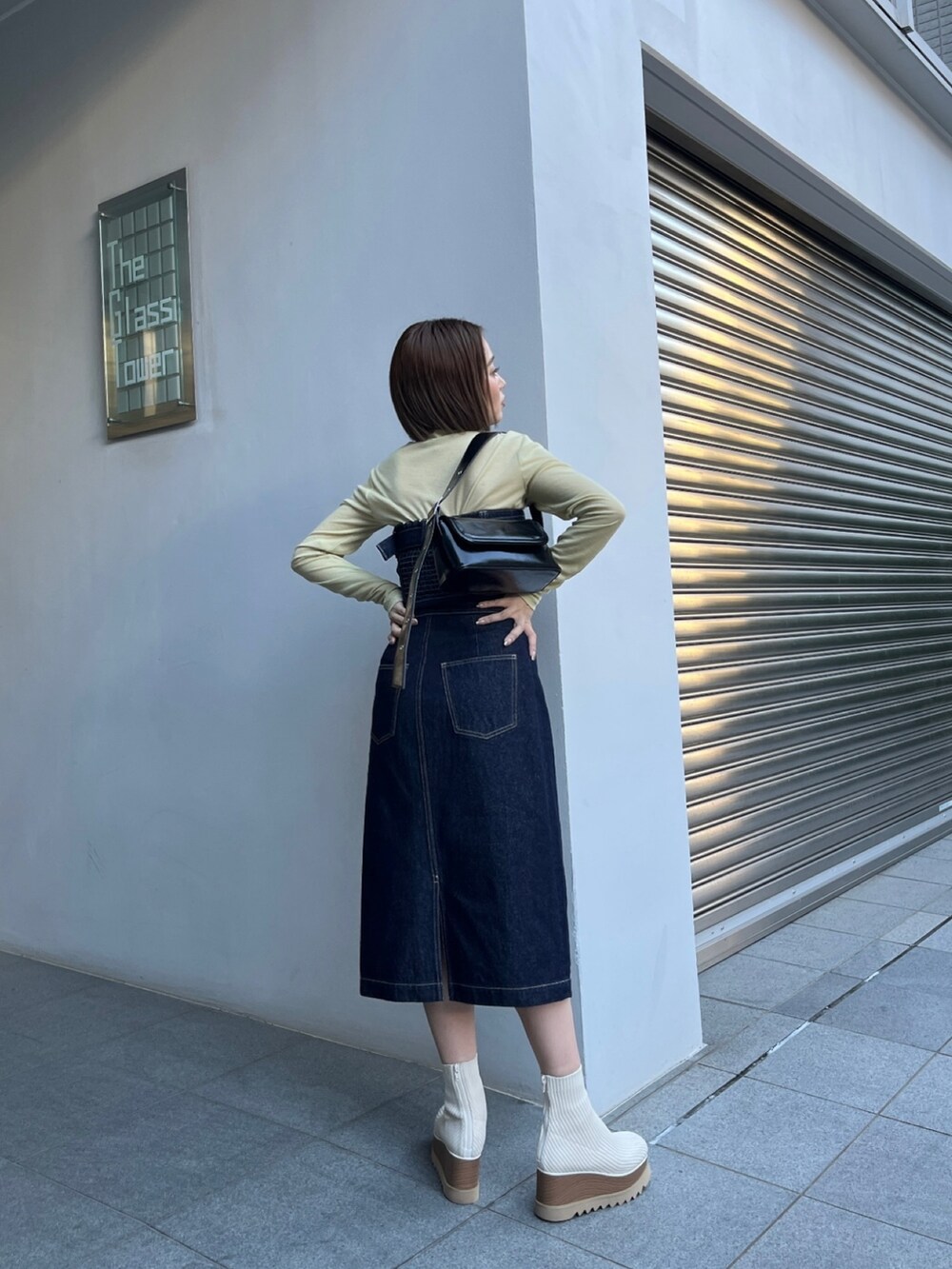 ブルー系のワンピース、ホワイト系のブーツ、イエロー系のTシャツ/カットソーを着用したレディースの秋コーディネートの3枚目の写真