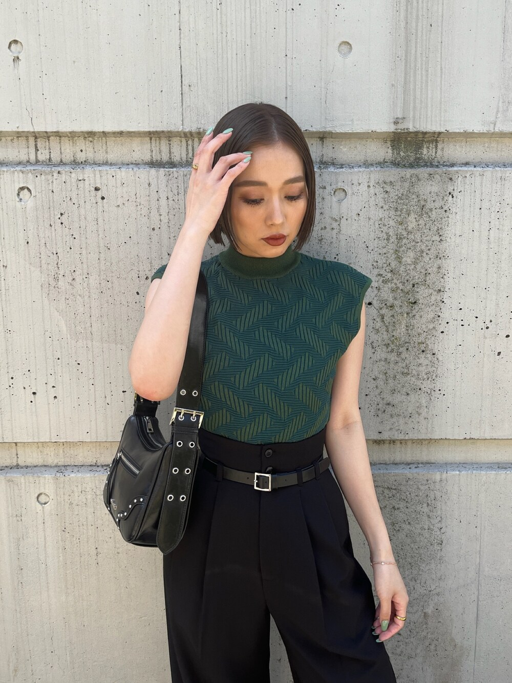 グリーン系のニット/セーター、ブラック系のその他パンツ、ブラック系のブーツを着用したレディースの夏コーディネートの7枚目の写真