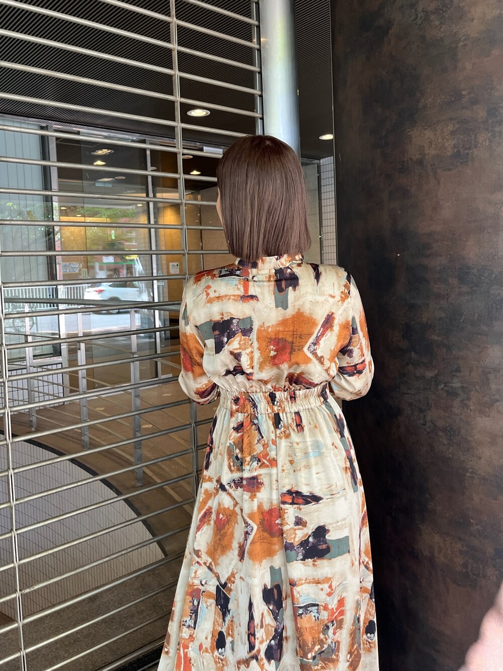 ブラウン系のブーツ、オレンジ系のワンピースを着用したレディースの秋コーディネートの5枚目の写真