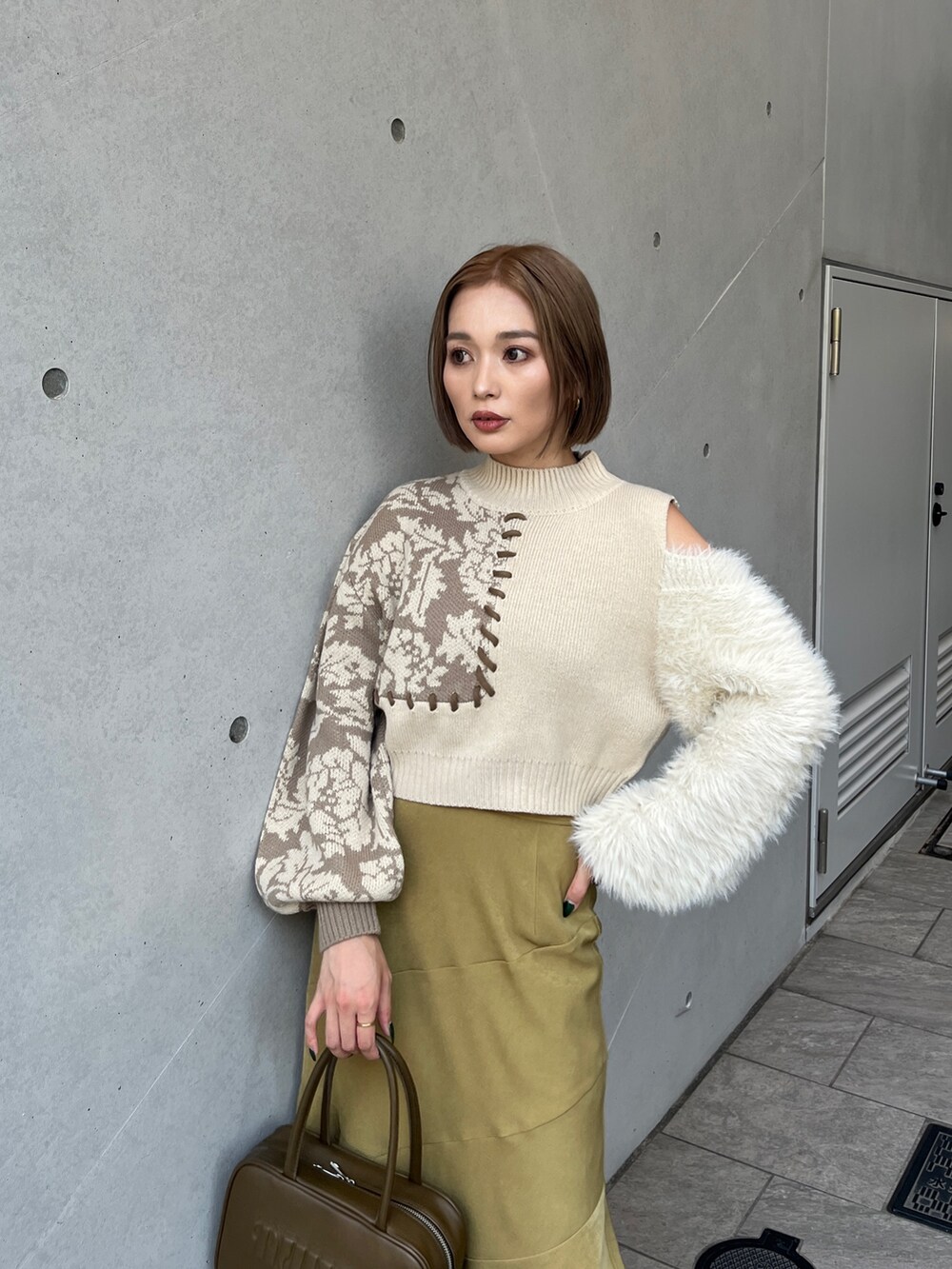 ホワイト系のニット/セーター、イエロー系のボストンバッグ、ホワイト系のブーツを着用したレディースの秋コーディネートの8枚目の写真