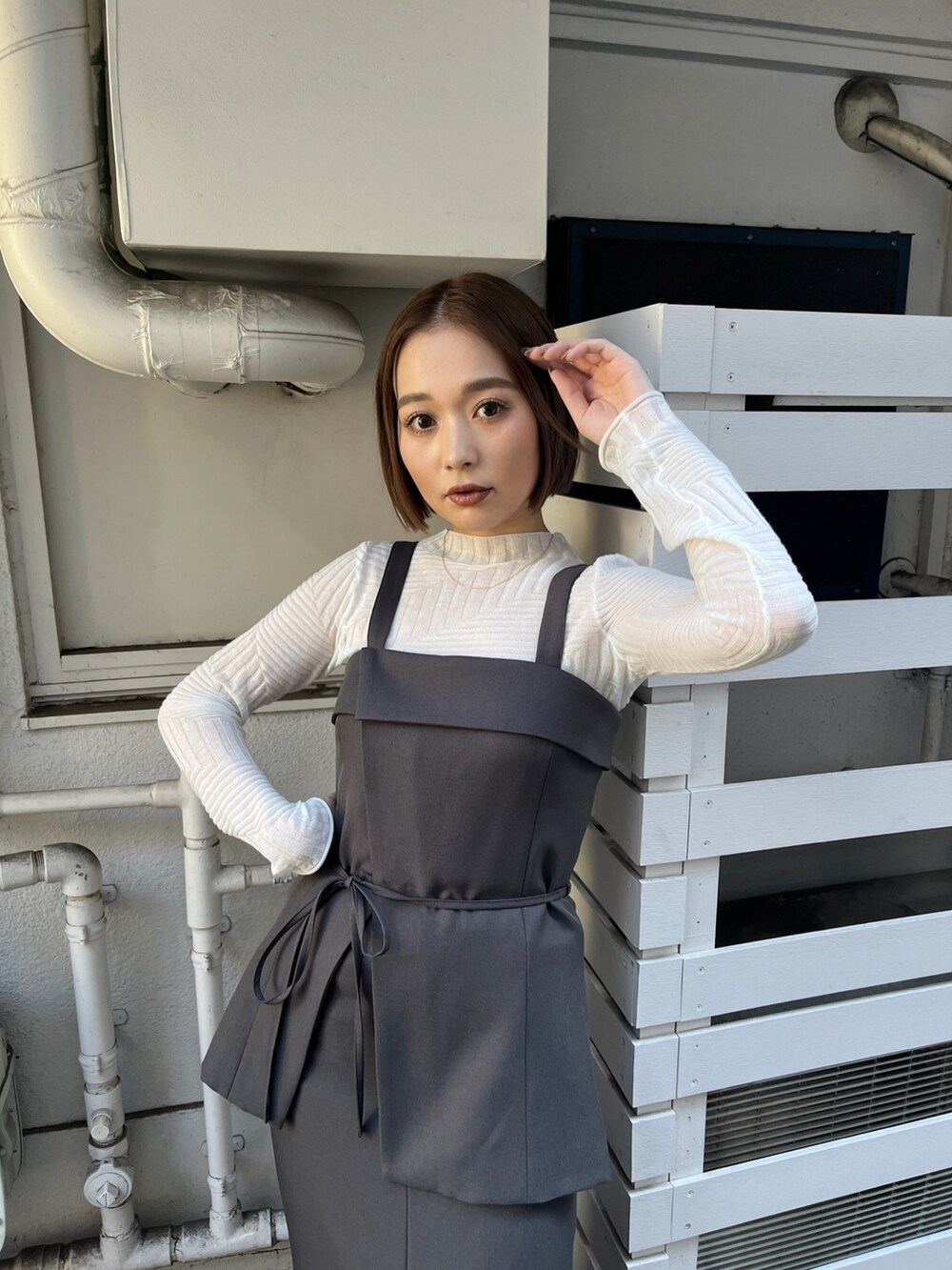 グレー系のシャツ/ブラウス、グレー系のスカート、ホワイト系のニット/セーターを着用したレディースの冬コーディネートの6枚目の写真