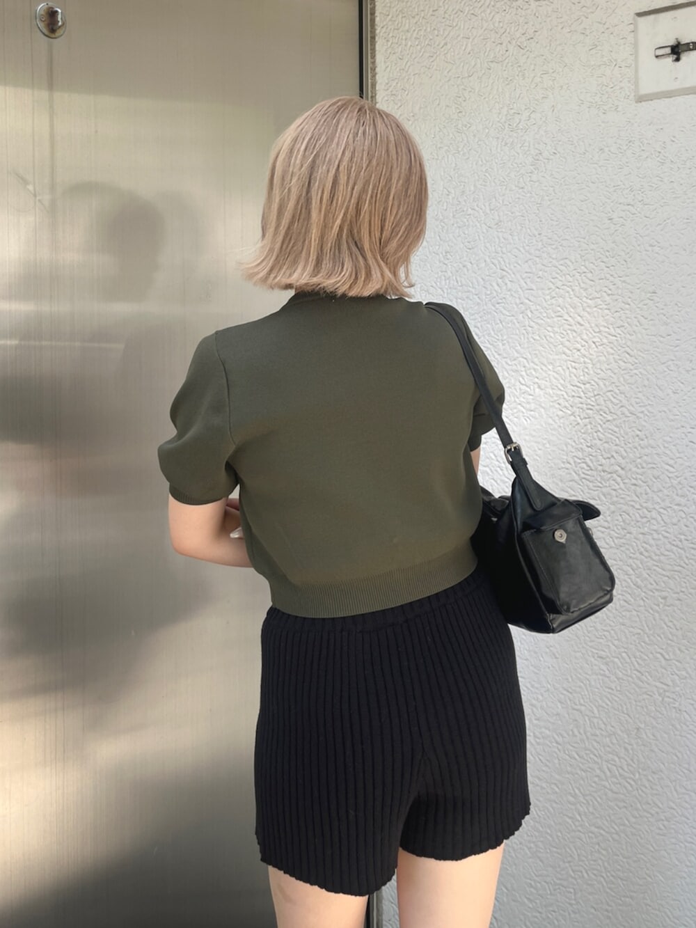 グリーン系のニット/セーター、ブラック系のその他パンツ、ブラック系のブーツを着用したレディースの秋コーディネートの6枚目の写真