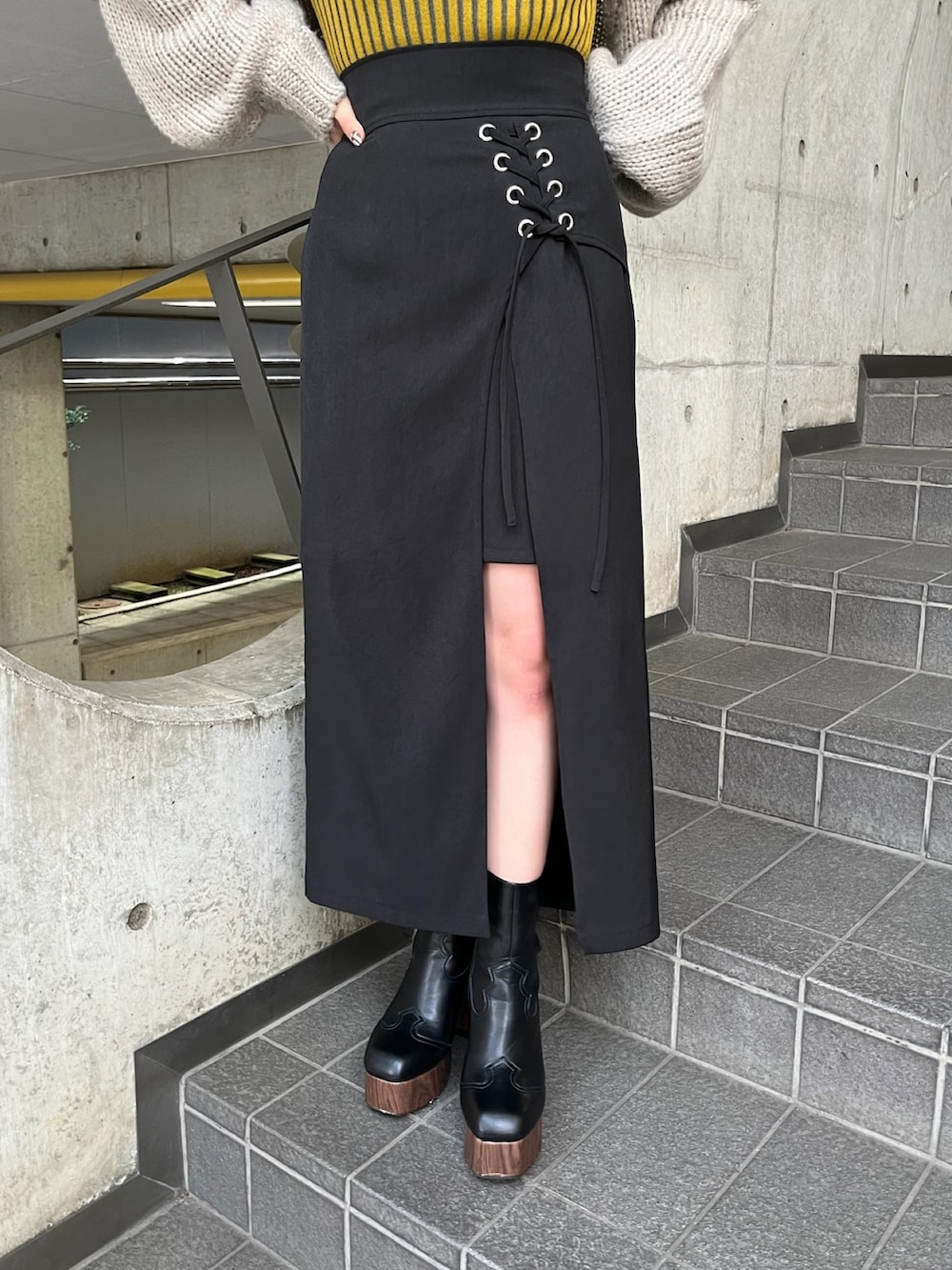 ベージュ系のトレンチコート、イエロー系のニット/セーター、ブラック系のスカートを着用したレディースの夏コーディネートの10枚目の写真