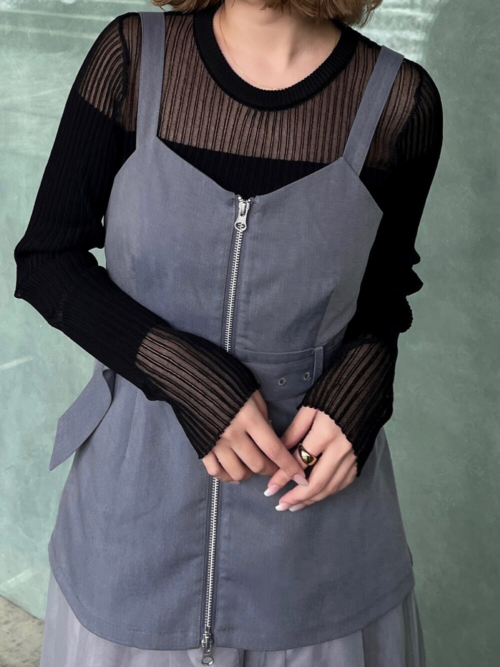 ブラック系のニット/セーター、グレー系のジャンパースカート、ブラック系のブーツを着用したレディースの春コーディネートの7枚目の写真