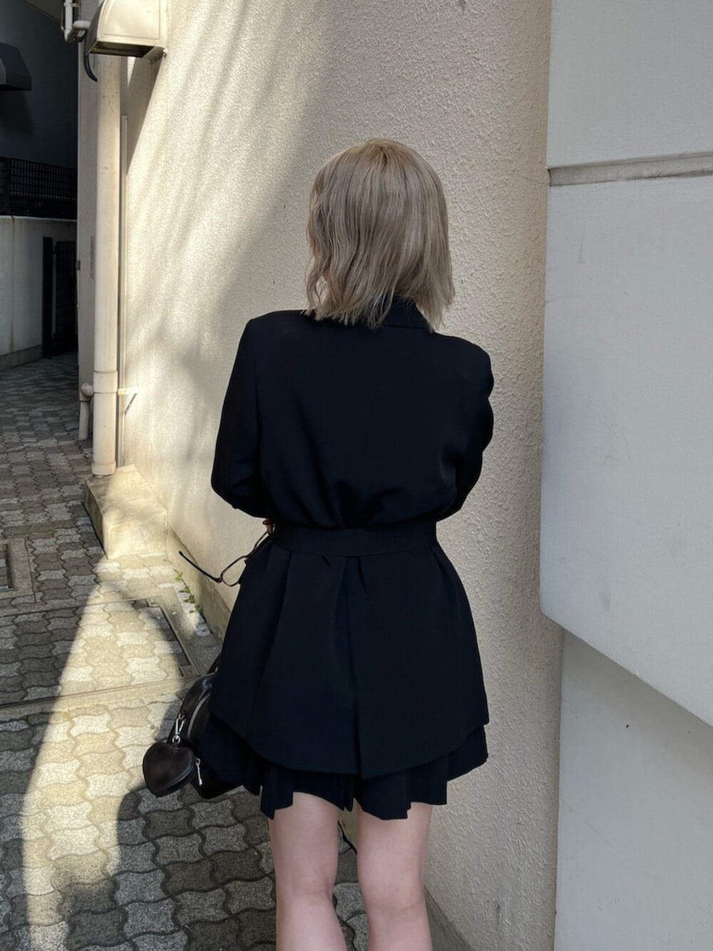 ブラック系のブーツ、ブラック系のテーラードジャケット、ブラウン系のキャミソールを着用したレディースの春コーディネートの9枚目の写真