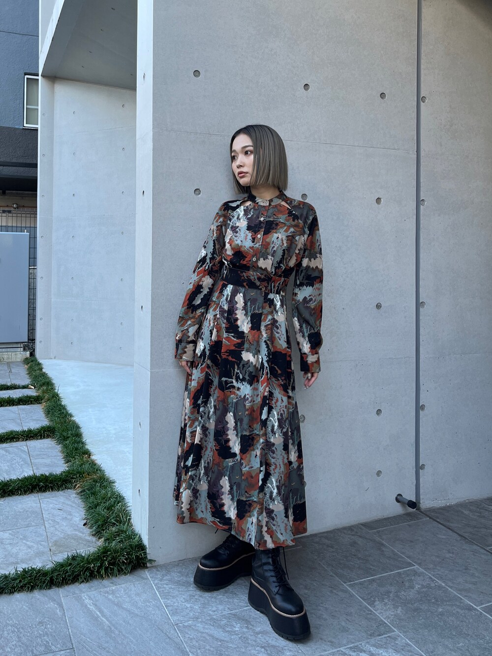 グレー系のブルゾン、ブラウン系のワンピース、ブラック系のブーツを着用したレディースの秋コーディネートの5枚目の写真