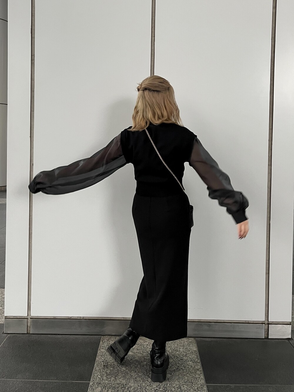 ブラック系のニット/セーターを着用したレディースの冬コーディネートの2枚目の写真