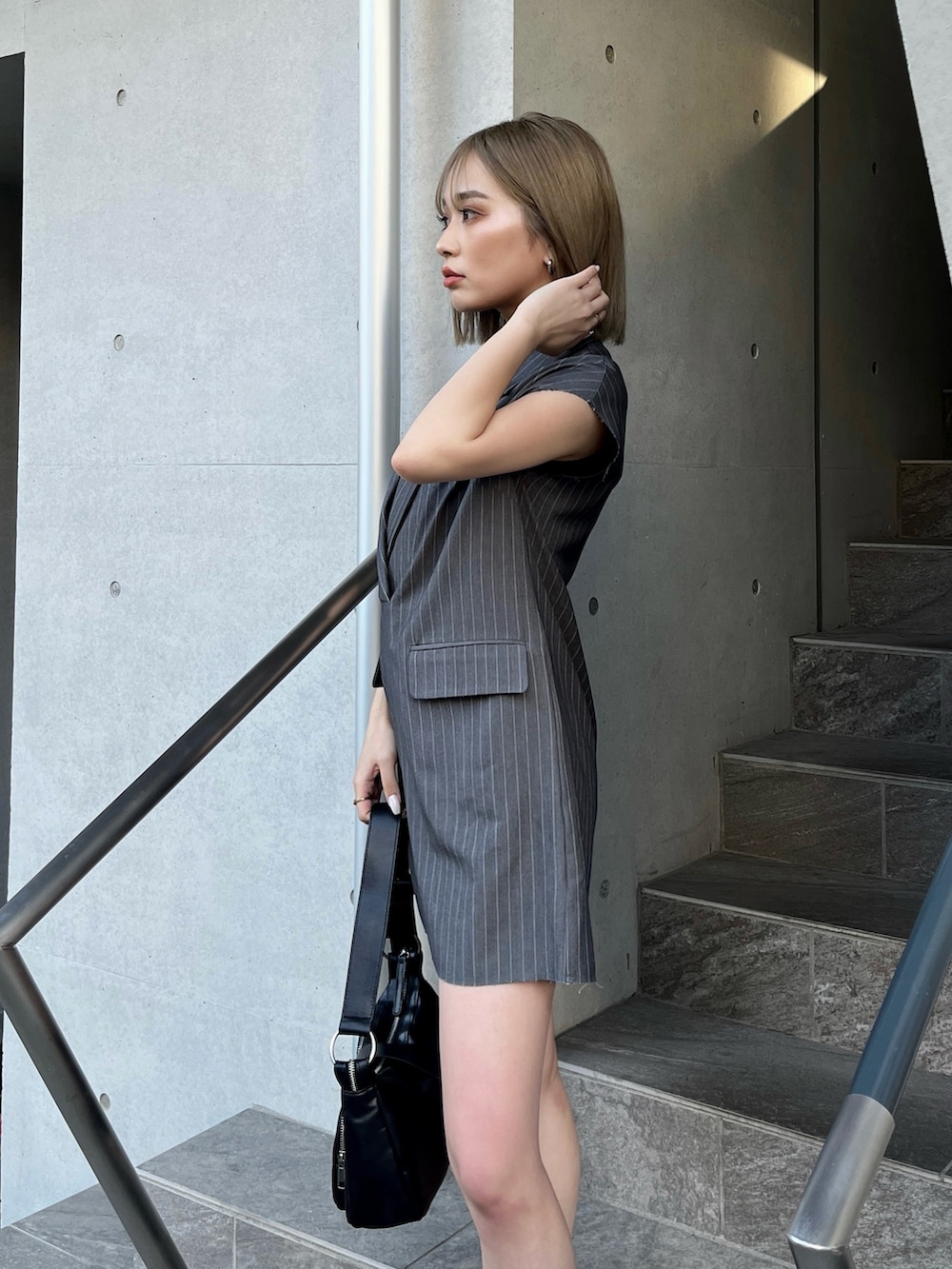 グレー系のワンピース、ブラック系のサンダル、ブラック系のニット/セーターを着用したレディースの夏コーディネートの5枚目の写真