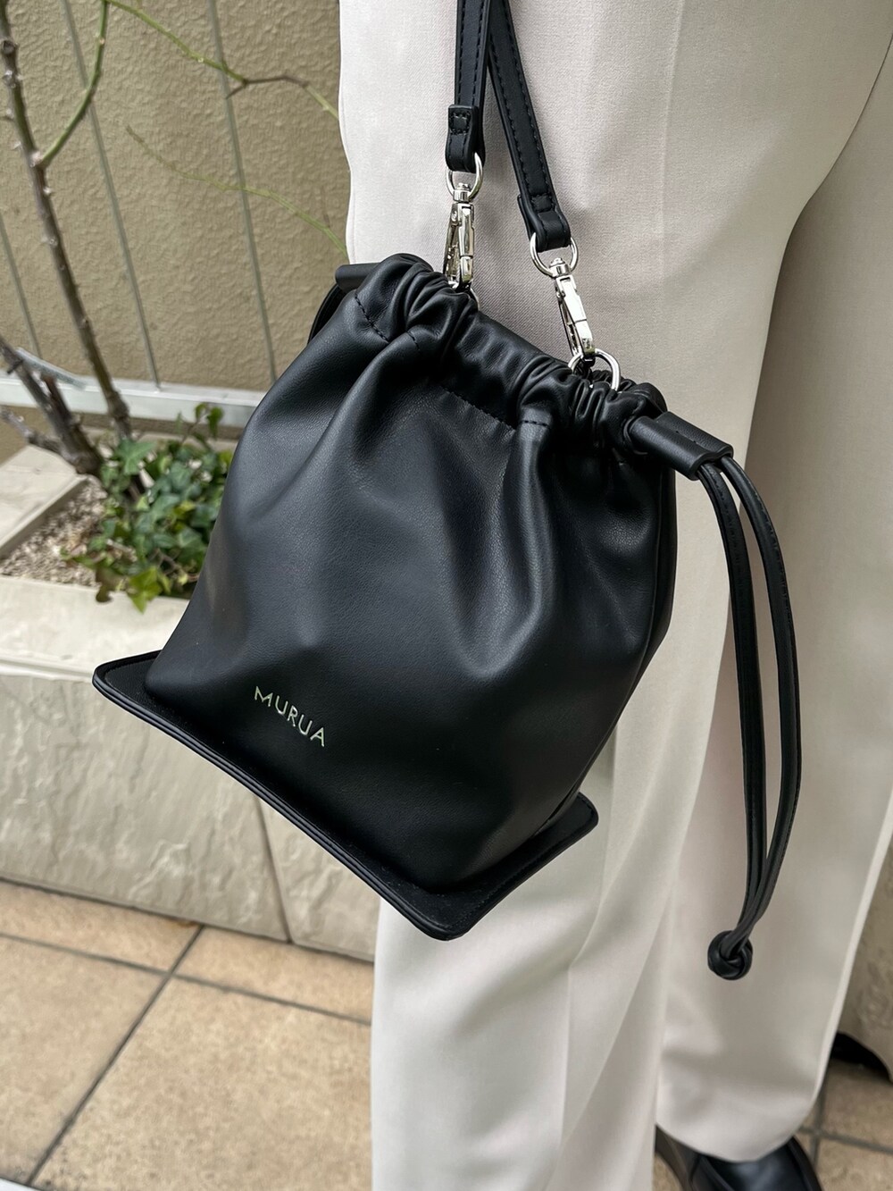 ブラック系のローファー、ベージュ系のスラックス、ブラック系のハンドバッグを着用したレディースの冬コーディネートの9枚目の写真