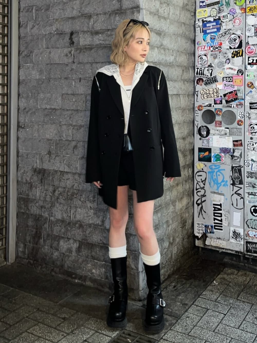 ブラック系のブーツ、ホワイト系のパーカー、ブラック系のテーラードジャケットを着用したレディースの春コーディネートの2枚目の写真