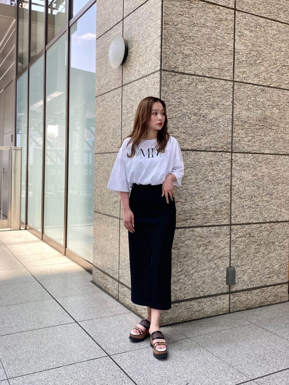 ブラック系のスカート、ホワイト系のTシャツ/カットソー、その他のサンダルを着用したレディースの春コーディネートの2枚目の写真