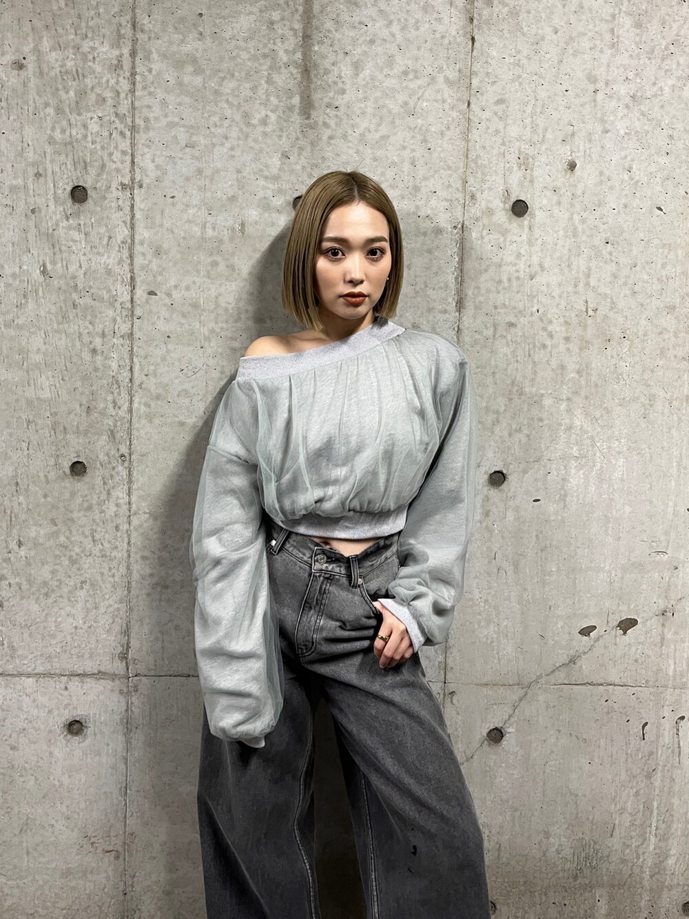 グレー系のスウェット、ブラック系のデニムパンツ、シルバー系のパンプスを着用したレディースの冬コーディネートの5枚目の写真