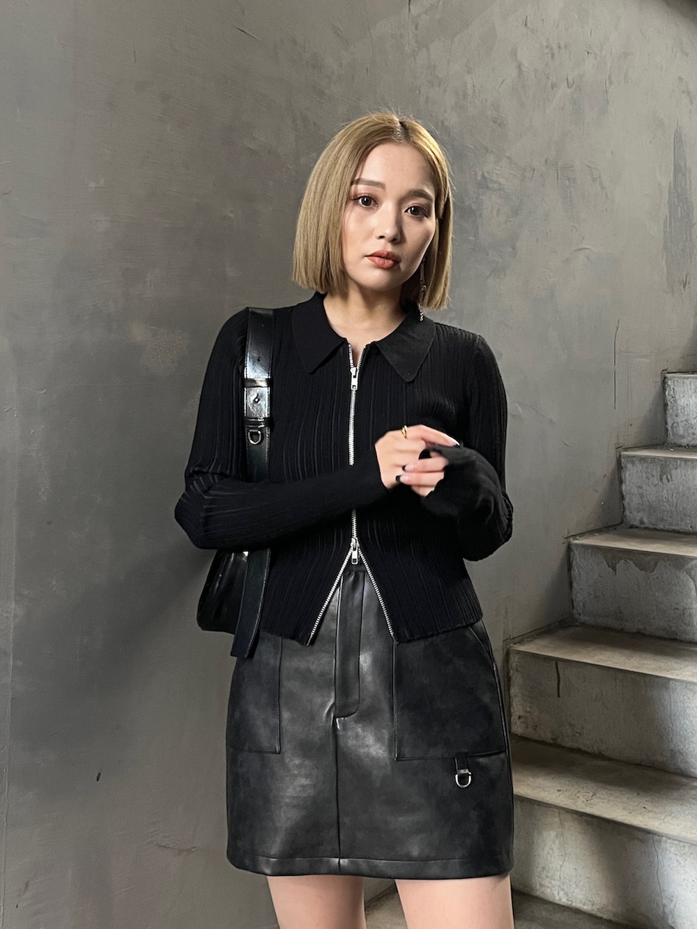 ブラック系のニット/セーター、ブラック系のブーツ、ブラック系のスカートを着用したレディースの冬コーディネートの4枚目の写真