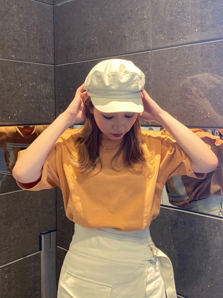 ホワイト系のスカート、オレンジ系のTシャツ/カットソー、ホワイト系のサンダルを着用したレディースの春コーディネートの5枚目の写真