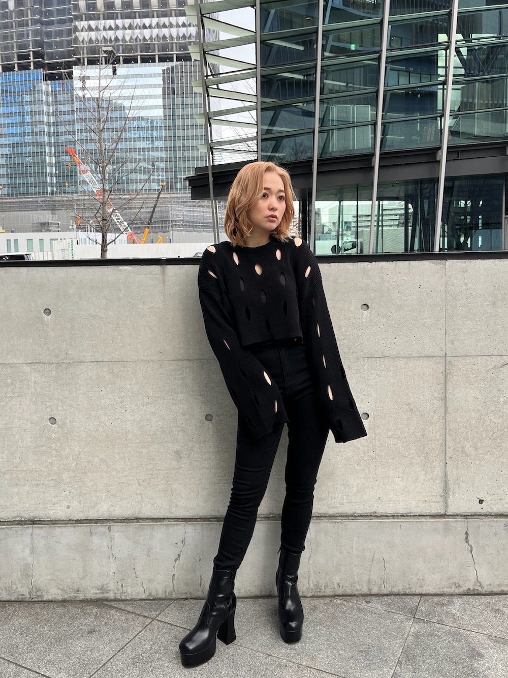 ホワイト系のブルゾン、ブラック系のニット/セーター、ブラック系のデニムパンツを着用したレディースの冬コーディネートの4枚目の写真