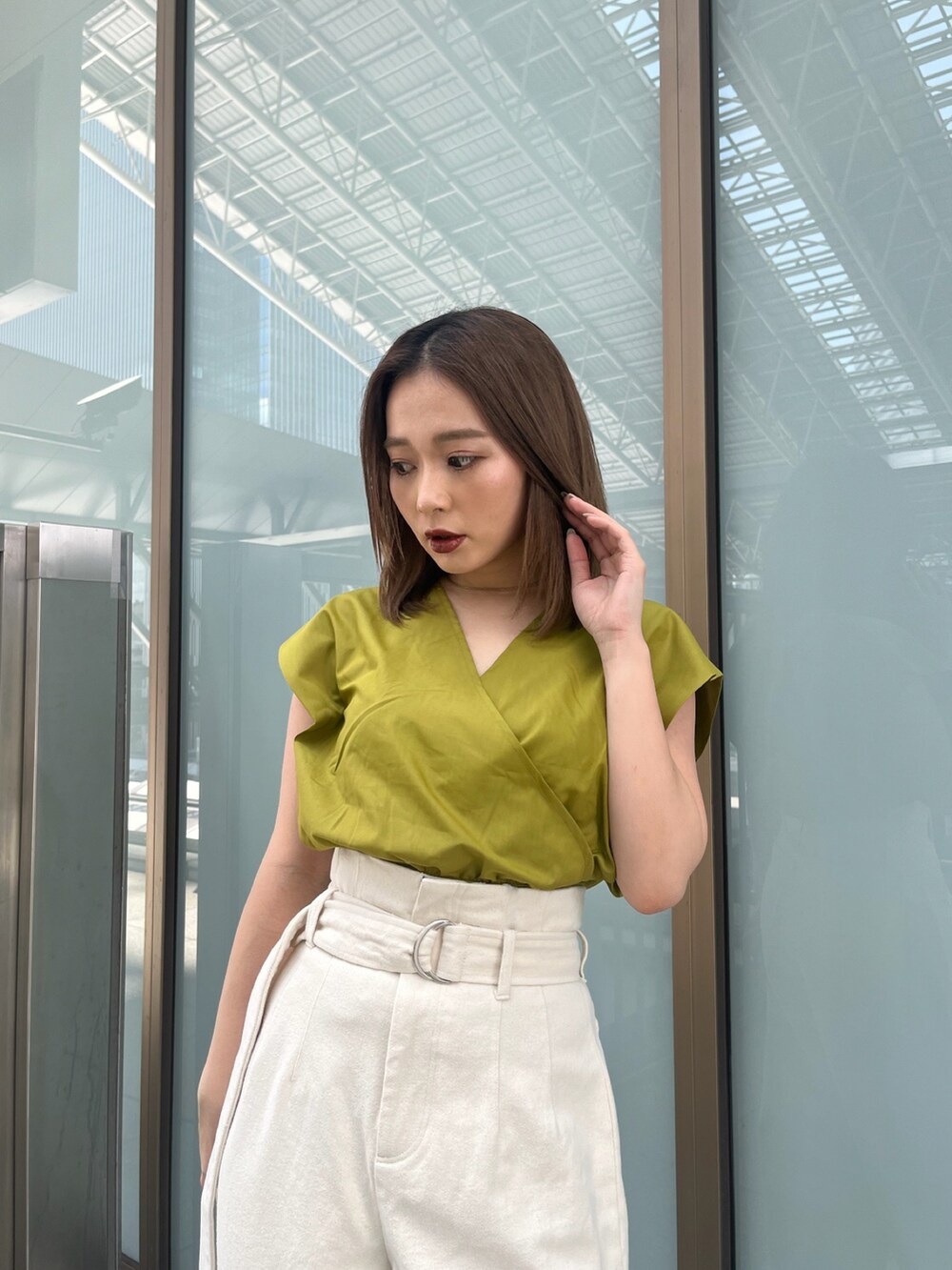 イエロー系のシャツ/ブラウス、ホワイト系のデニムパンツ、ブラック系のサンダルを着用したレディースの春コーディネートの3枚目の写真