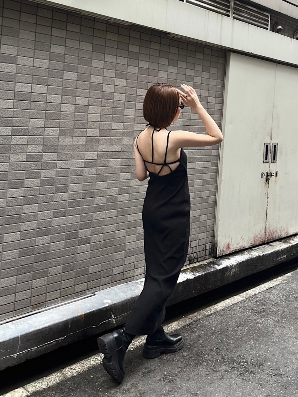 ブラック系のワンピース、ブラック系のサングラスを着用したレディースの春コーディネートの2枚目の写真