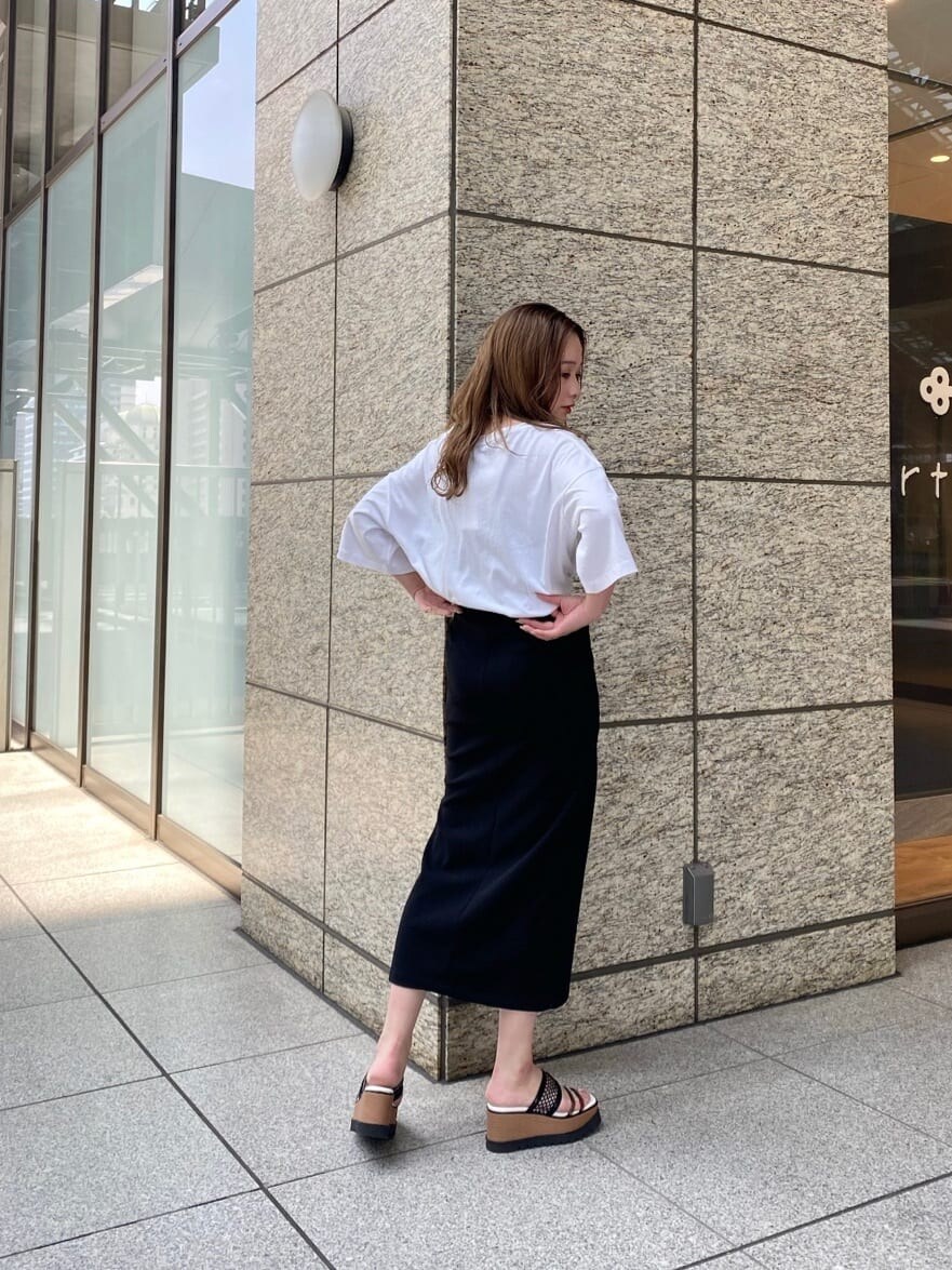 ブラック系のスカート、ホワイト系のTシャツ/カットソー、その他のサンダルを着用したレディースの春コーディネートの5枚目の写真