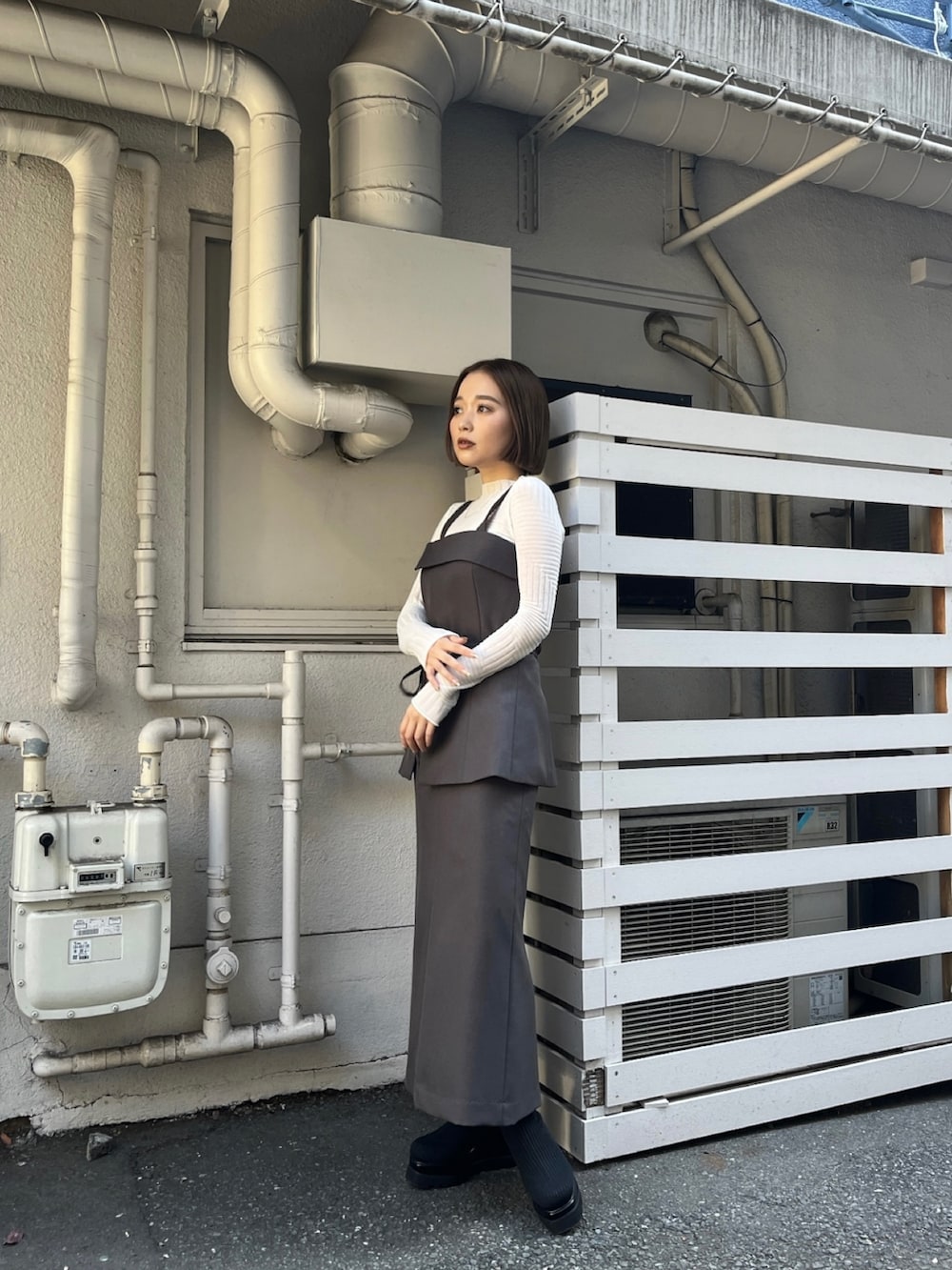 グレー系のシャツ/ブラウス、グレー系のスカート、ホワイト系のニット/セーターを着用したレディースの冬コーディネートの3枚目の写真