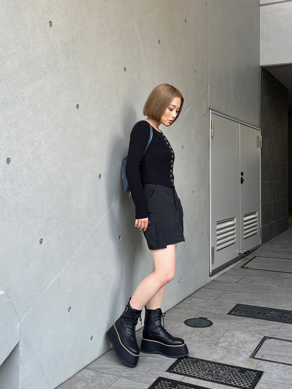 ブラック系のブーツ、ブラック系のスカート、ブラック系のニット/セーターを着用したレディースの夏コーディネートの3枚目の写真